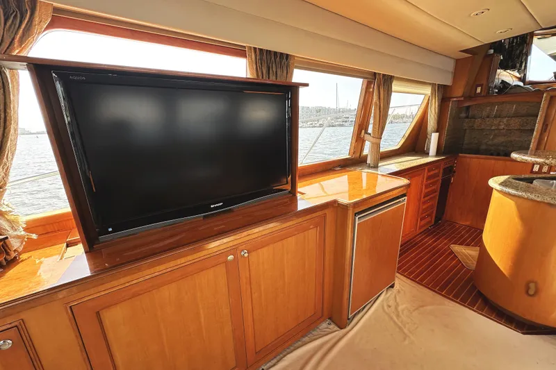 Slide: The Image of Luxurious interior of 2004 McKinna 57 PHMY yacht with large TV and wooden cabinetry. - 30