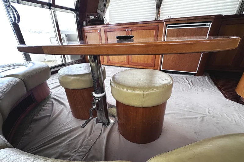 Slide: The Image of Interior of 2004 McKinna 57 PHMY yacht with wooden table and cushioned seating. - 36