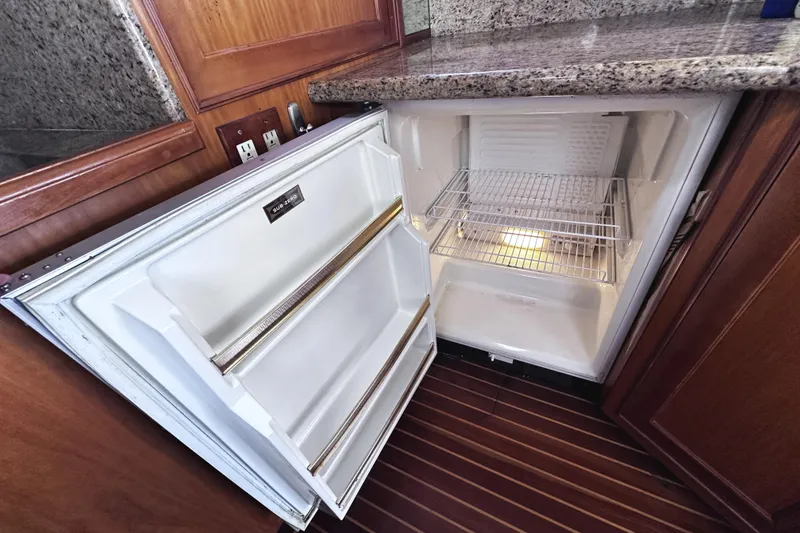 Slide: The Image of Open refrigerator in 2004 McKinna 57 PHMY yacht, featuring wooden cabinetry and granite countertop. - 43