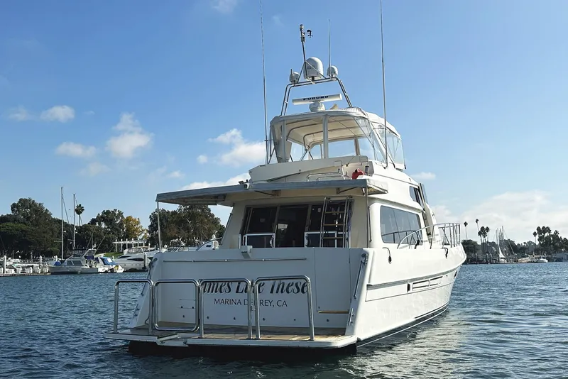 Slide: The Image of 2004 McKinna 57 PHMY Widebody yacht docked in a marina under a clear blue sky. - 7