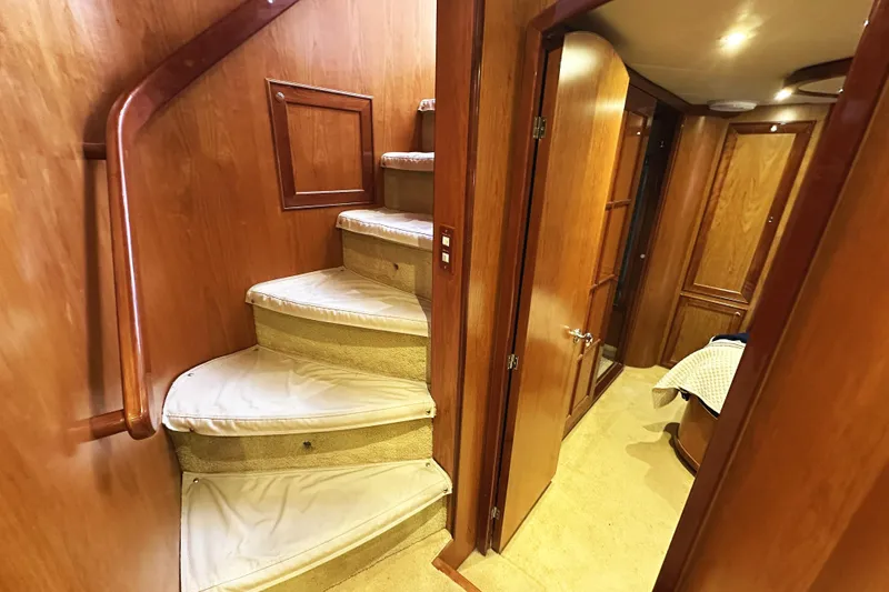Slide: The Image of Interior of 2004 McKinna 57 PHMY yacht, featuring wooden stairs and hallway. - 72