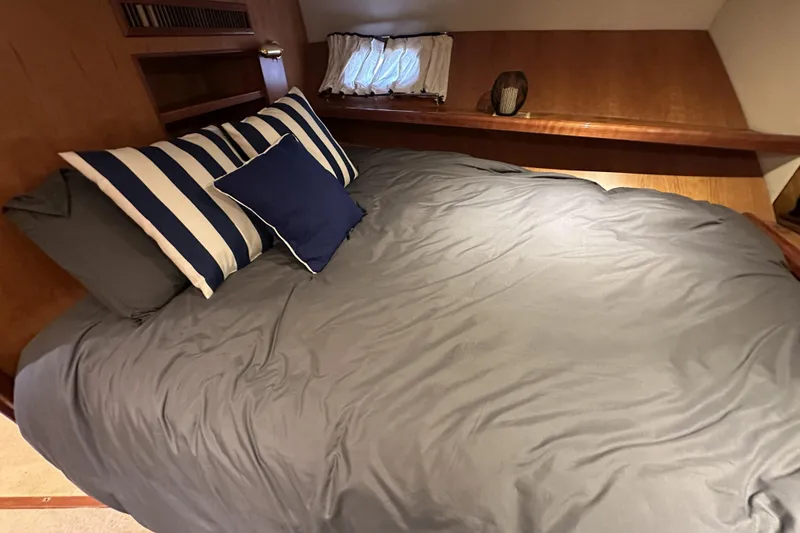 Slide: The Image of Cozy bedroom in 2004 McKinna 57 PHMY yacht with striped pillows and wooden accents. - 88