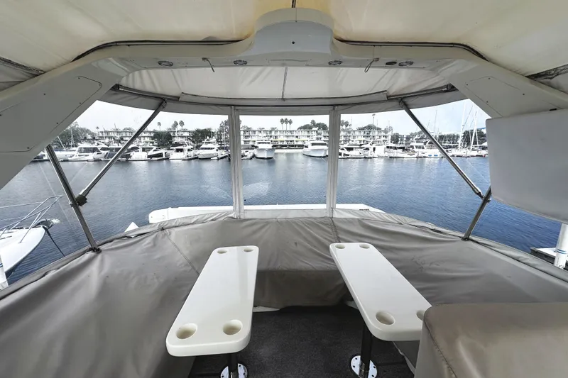 Slide: The Image of 2004 McKinna 57 PHMY yacht interior with marina view, featuring seating and tables. - 92
