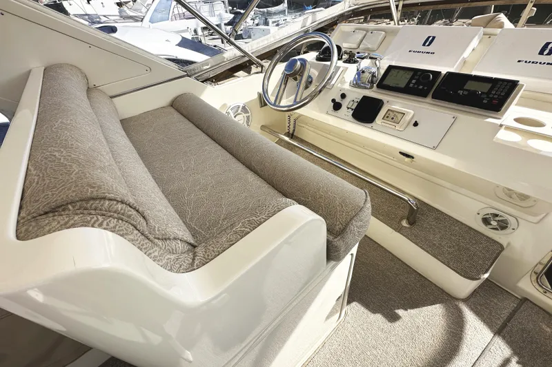 Slide: The Image of 2004 McKinna 57 PHMY Widebody yacht helm with plush seating and advanced navigation controls. - 95