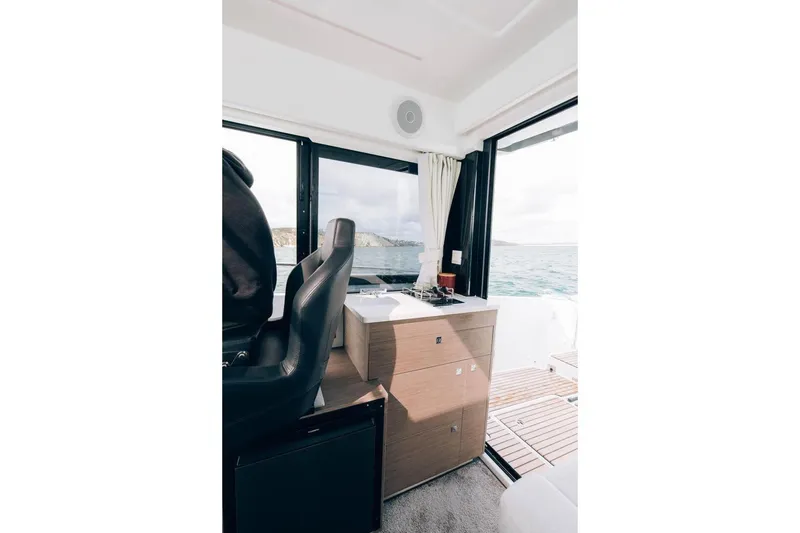 Slide: The Image of Interior of 2026 Jeanneau NC895 Sport boat with helm, window, and sea view. - 16