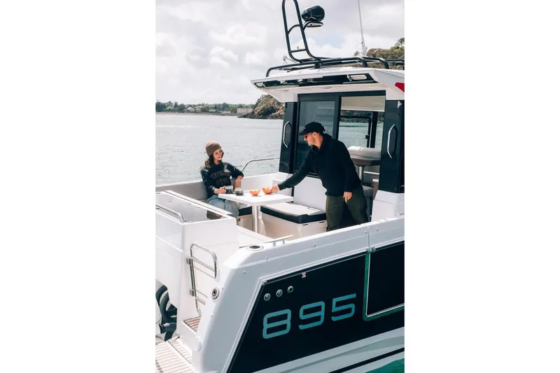 Slide: The Image of 2026 Jeanneau NC895 Sport boat with people enjoying a meal on deck. - 3