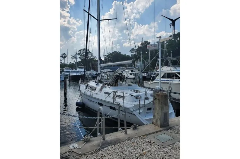 The Image of 1994 Hunter Passage 42 sailboat docked at a marina under a partly cloudy sky. - 0