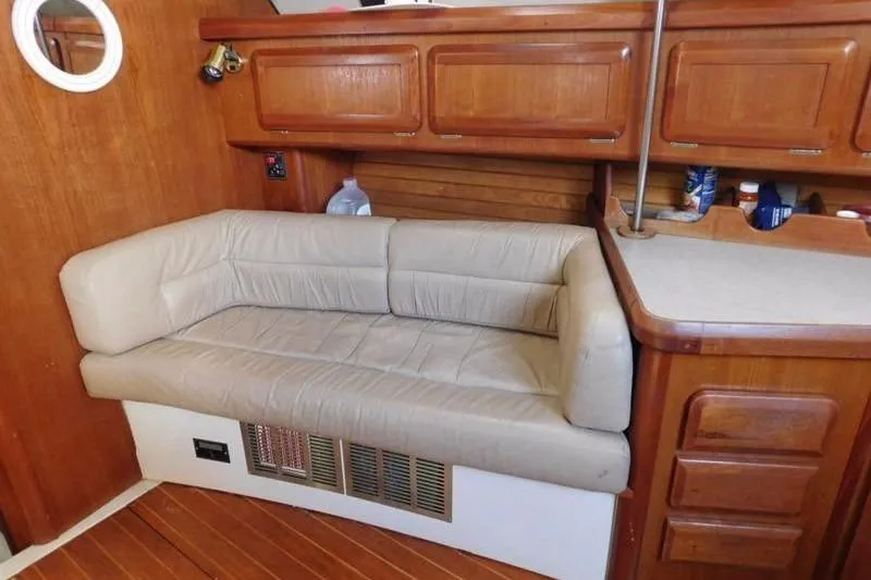 Slide: The Image of 1994 Hunter Passage 42 yacht interior with beige leather seating and wooden cabinetry. - 18