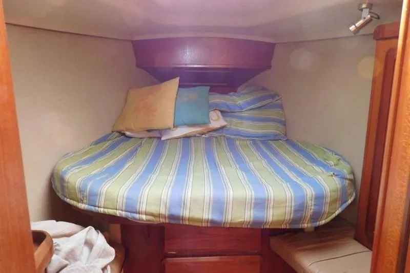 Slide: The Image of Cozy cabin interior of 1994 Hunter Passage 42 sailboat with striped bedding. - 22