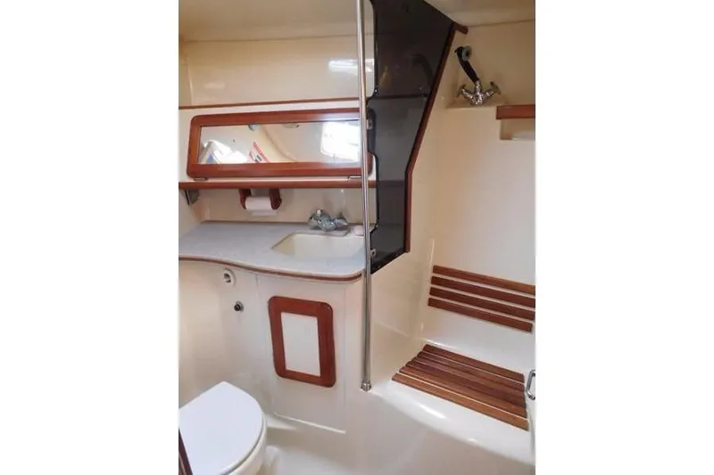 Slide: The Image of 1994 Hunter Passage 42 yacht bathroom with sink, mirror, and wooden accents. - 23