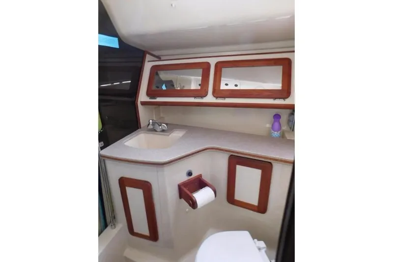 Slide: The Image of 1994 Hunter Passage 42 yacht bathroom with sink, mirror, and wooden accents. - 25