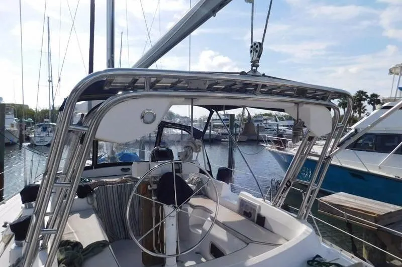 Slide: The Image of 1994 Hunter Passage 42 sailboat cockpit with steering wheel, docked in marina. - 3