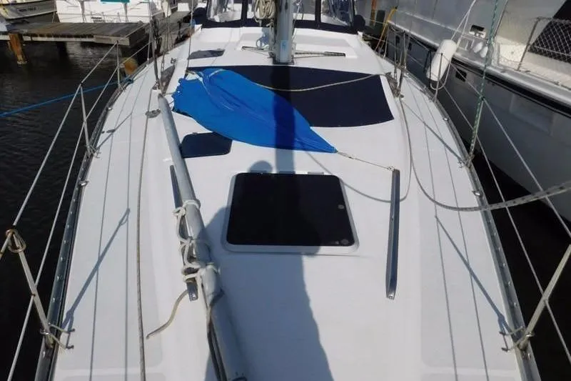 Slide: The Image of 1994 Hunter Passage 42 sailboat deck with blue cover, docked at marina. - 4