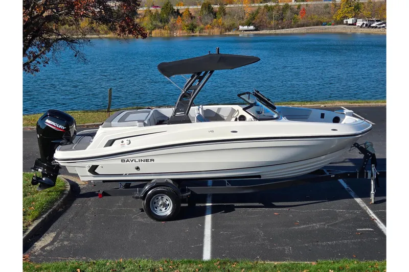 The Image of 2024 Bayliner VR5 Bowrider OB boat on trailer by a lake. - 0