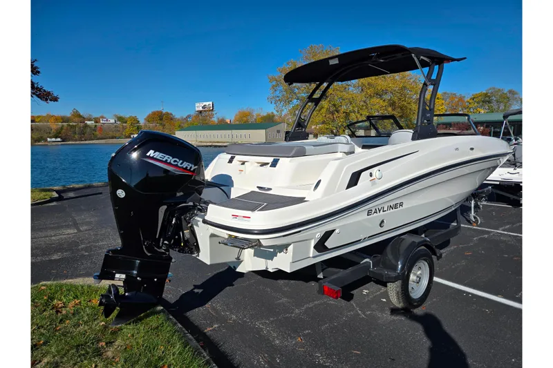 Slide: The Image of 2024 Bayliner VR5 Bowrider OB with Mercury outboard engine, parked near a scenic lake. - 1