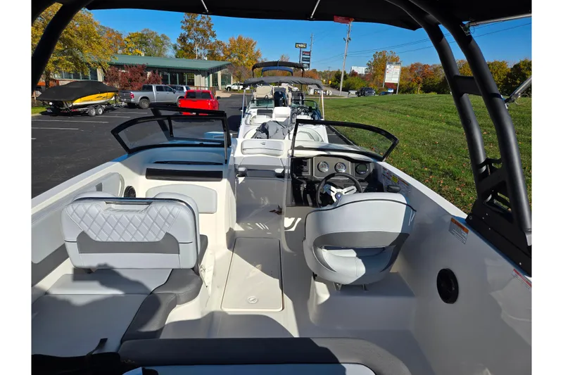 Slide: The Image of 2024 Bayliner VR5 Bowrider OB interior with modern seating and dashboard, parked outdoors. - 10