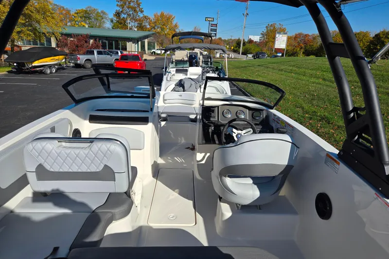 Slide: The Image of 2024 Bayliner VR5 Bowrider OB interior with modern seating and dashboard, parked outdoors. - 11