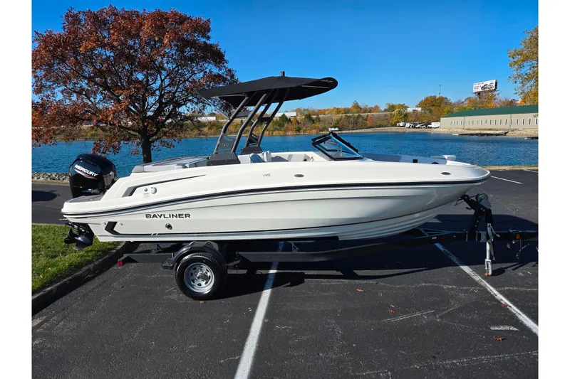Slide: The Image of 2024 Bayliner VR5 Bowrider OB boat on trailer by a scenic lake. - 9