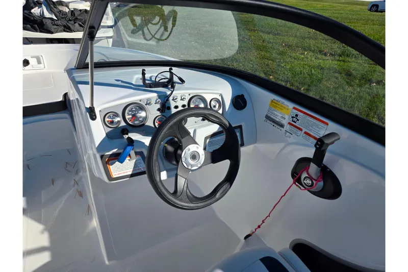 Slide: The Image of 2023 Tahoe 185 S boat dashboard with steering wheel and control panel. - 13