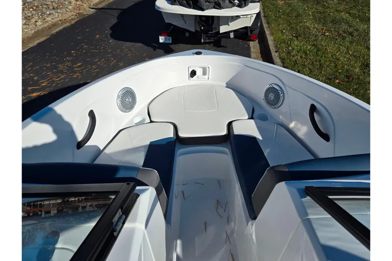 Slide: The Image of 2023 Tahoe 185 S boat interior with seating and speakers, parked on a road. - 16