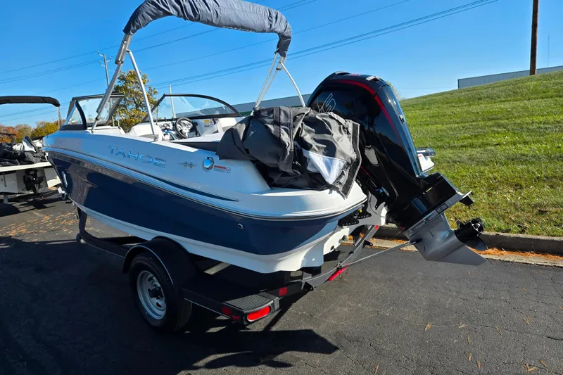 Slide: The Image of 2023 Tahoe 185 S boat on trailer, parked outdoors, with outboard motor. - 3