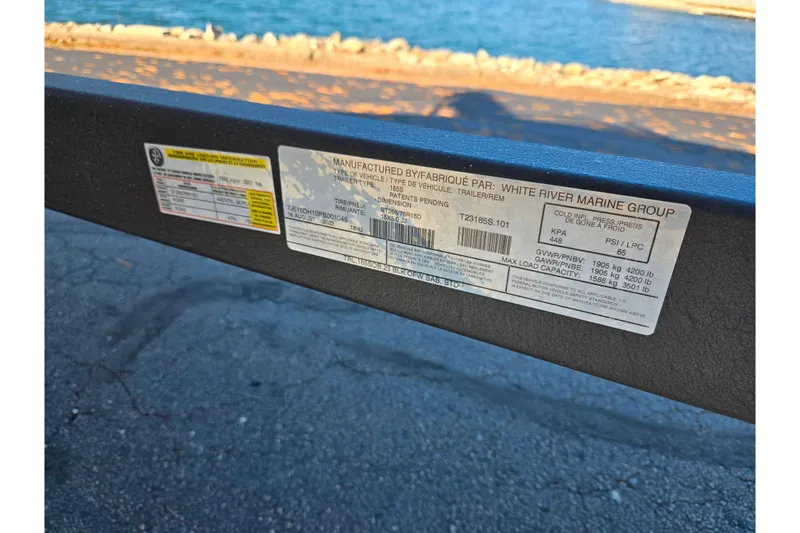 Slide: The Image of Label on 2023 Tahoe 185 S trailer by White River Marine Group near water. - 8