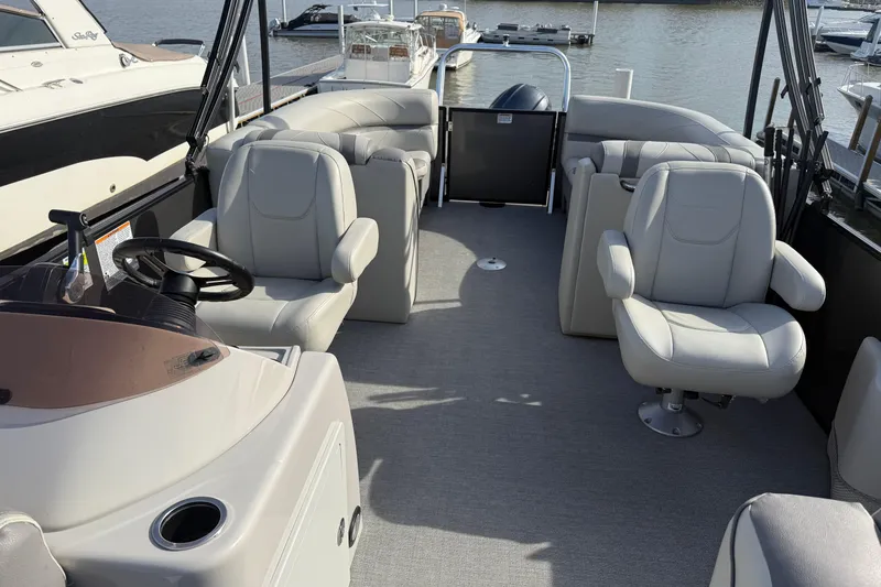 Slide: The Image of 2020 SunChaser Geneva Sport 22 LR DH pontoon boat interior with plush seating and steering console. - 12