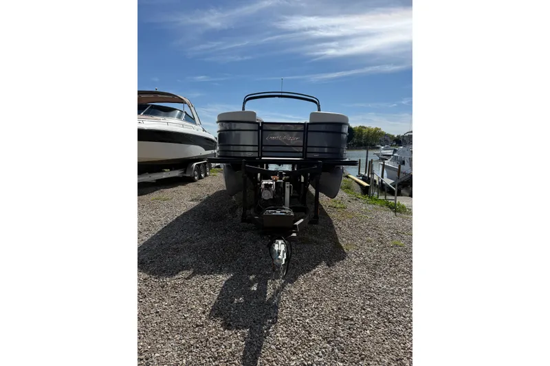 Slide: The Image of 2020 SunChaser Geneva Sport 22 LR DH pontoon boat on trailer, parked near water. - 18