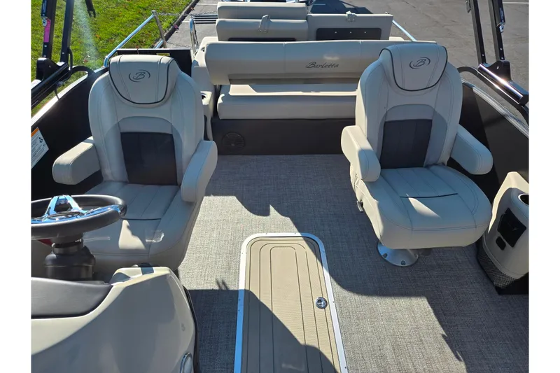 Slide: The Image of 2021 Barletta C24UC boat interior with plush seating and steering wheel. - 12