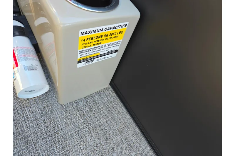 Slide: The Image of 2021 Barletta C24UC boat capacity label, 14 persons or 2010 lbs, on textured flooring. - 19