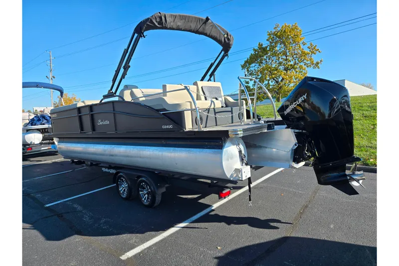 Slide: The Image of 2021 Barletta C24UC pontoon boat with Mercury outboard engine in parking lot. - 4