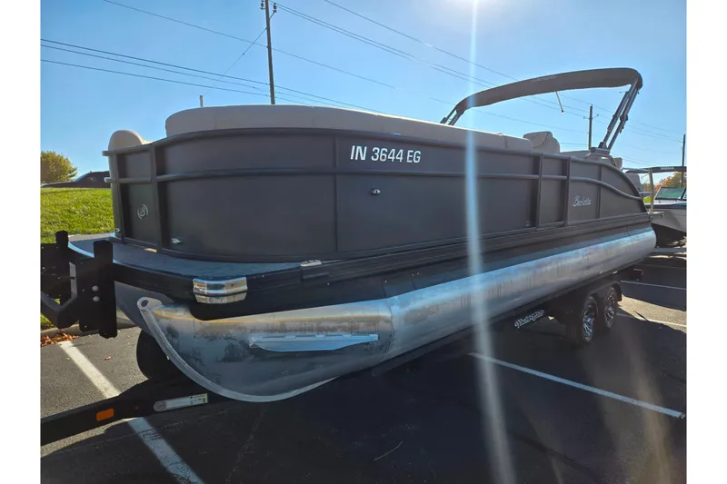 Slide: The Image of 2021 Barletta C24UC pontoon boat on trailer in parking lot, sunny day. - 6