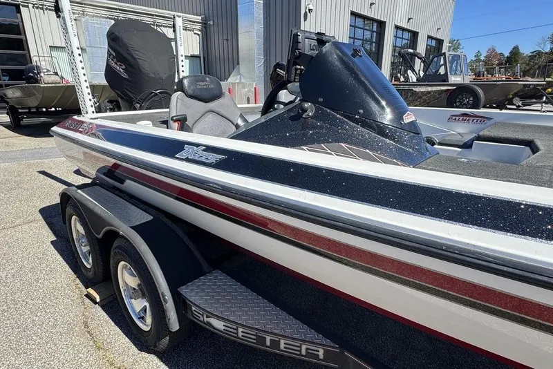 Slide: The Image of 2015 Skeeter ZX225 bass boat on trailer, parked outside a building. - 3