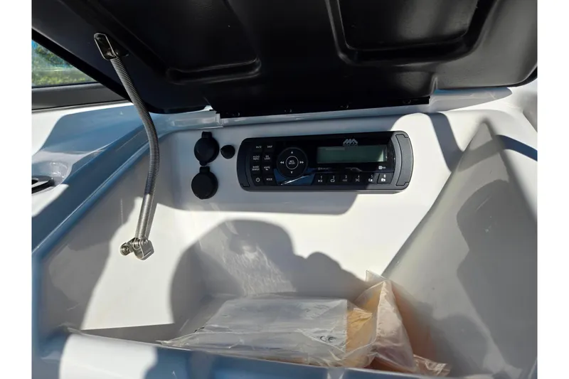 Slide: The Image of 2018 Yamaha Boats SX190 dashboard with audio system and storage compartment. - 14