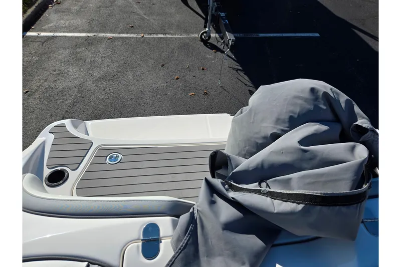 Slide: The Image of 2018 Yamaha Boats SX190 rear deck with cover, parked on asphalt. - 23