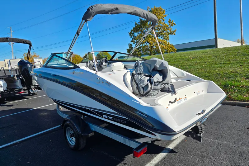 Slide: The Image of 2018 Yamaha Boats SX190 on trailer, parked outdoors, with canopy and sleek design. - 3