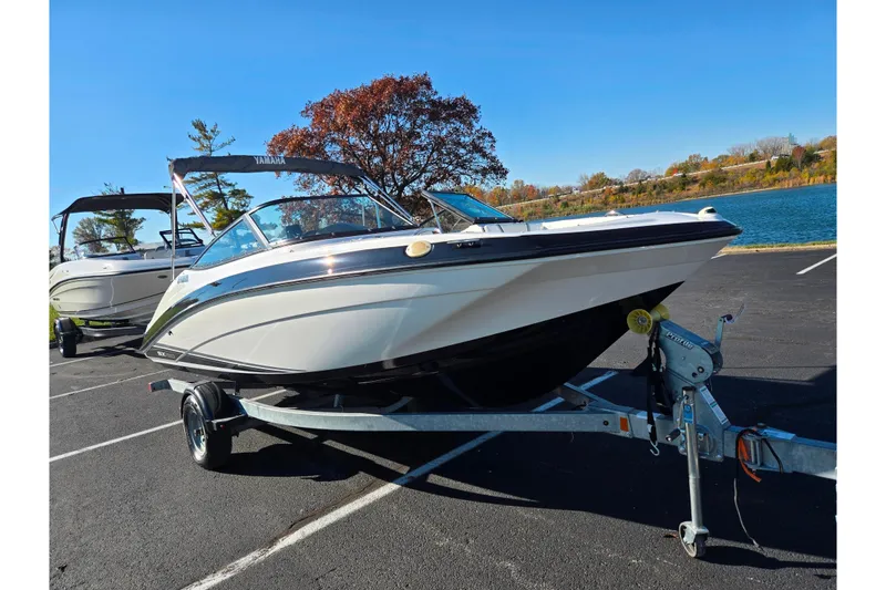 Slide: The Image of 2018 Yamaha Boats SX190 on trailer by a lake, under clear blue sky. - 8
