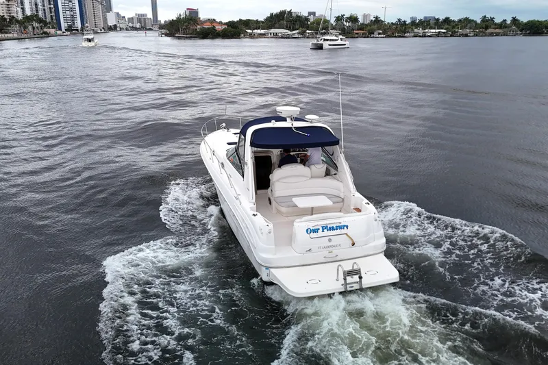 Slide: The Image of 1999 Sea Ray 340 yacht cruising on a scenic waterway near city skyline. - 10