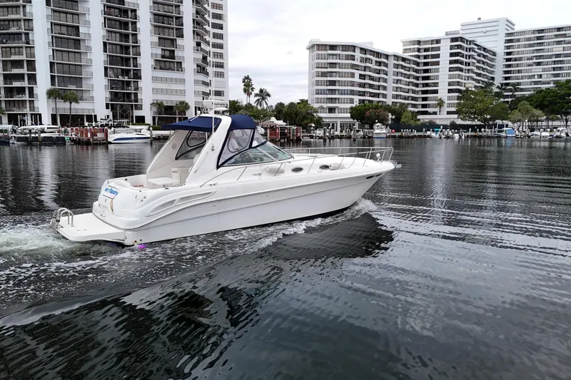 Slide: The Image of 1999 Sea Ray 340 boat cruising near waterfront buildings. - 12