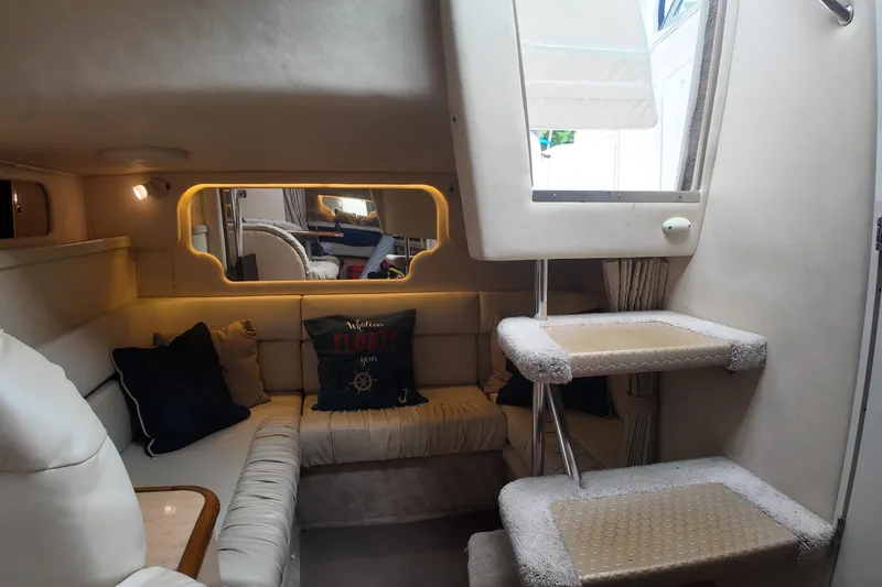 Slide: The Image of 1999 Sea Ray 340 yacht interior with cozy seating and decorative pillows. - 16