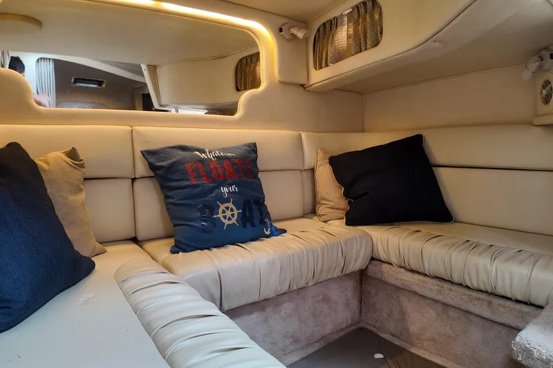 Slide: The Image of Interior of a 1999 Sea Ray 340 boat with cozy seating and decorative pillows. - 18