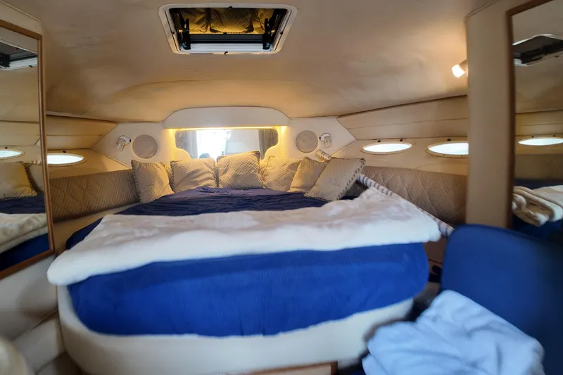 Slide: The Image of 1999 Sea Ray 340 cabin interior with cozy bed and porthole windows. - 22