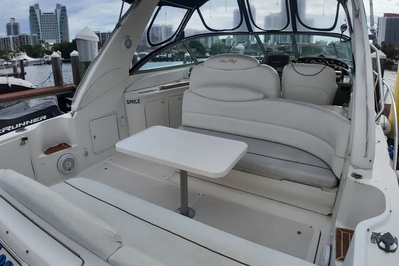 Slide: The Image of 1999 Sea Ray 340 boat interior with seating and table, docked in a marina. - 28