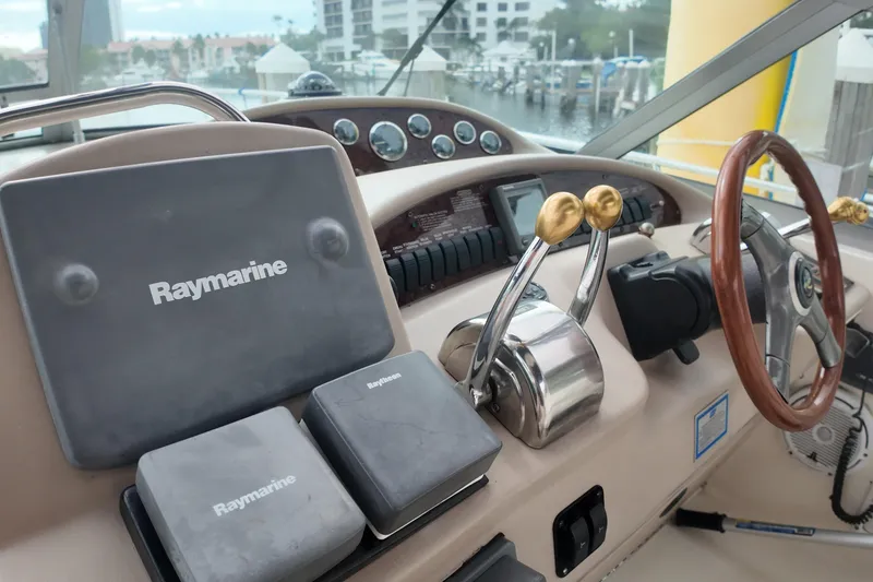 Slide: The Image of 1999 Sea Ray 340 boat helm with Raymarine navigation equipment and wooden steering wheel. - 30