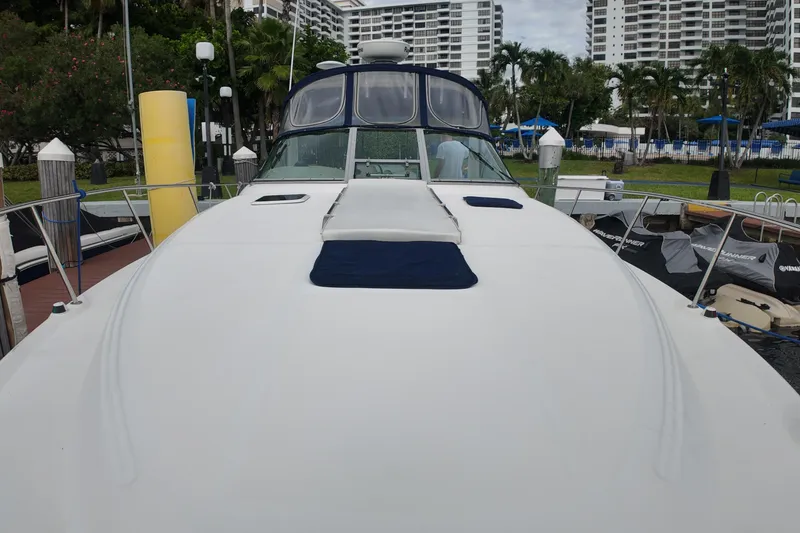 Slide: The Image of 1999 Sea Ray 340 yacht docked at marina with modern buildings in background. - 34