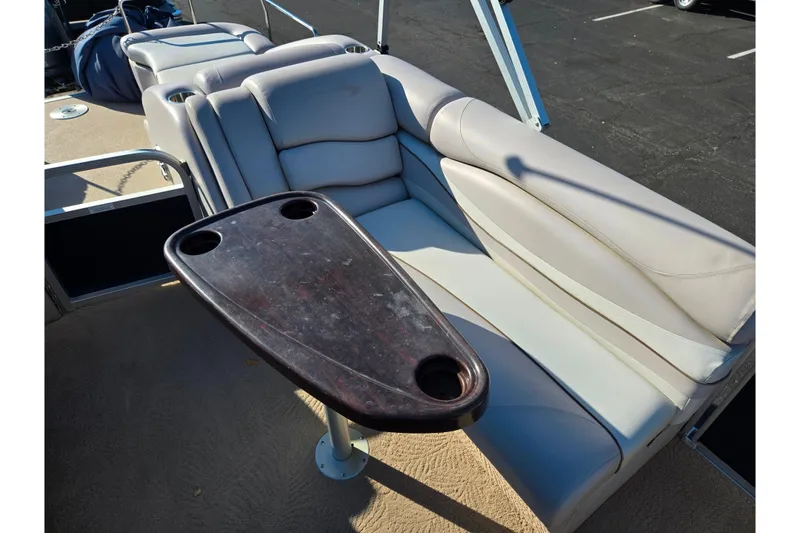 Slide: The Image of 2011 Bennington 2275RCW OB boat interior with cushioned seating and a wooden table. - 14