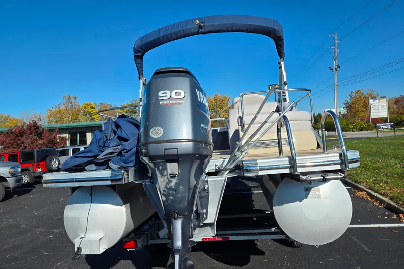 Slide: The Image of 2011 Bennington 2275RCW OB pontoon boat with Yamaha 90 four-stroke engine, parked outdoors. - 2