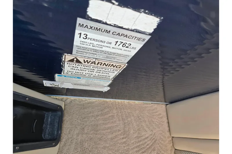 Slide: The Image of 2011 Bennington 2275RCW OB capacity and safety warning labels on boat interior. - 24