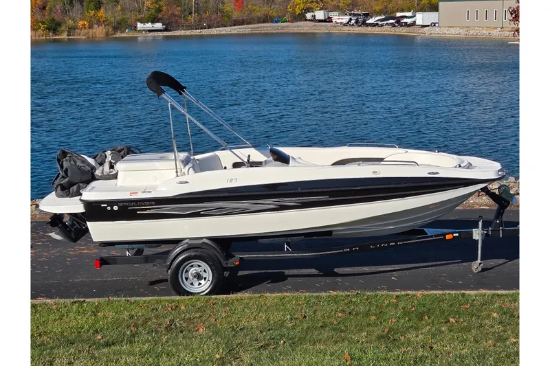 The Image of 2011 Bayliner 197 boat on trailer by a scenic lake. - 0