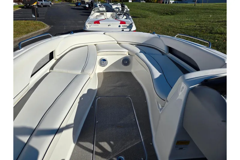 Slide: The Image of 2011 Bayliner 197 boat interior with white cushioned seating and carpeted floor. - 13